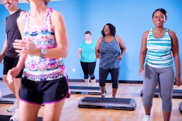 Studio group fitness class doing step aerobics at YMCA