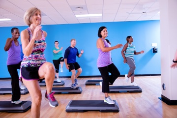 Studio group fitness class doing step aerobics at YMCA