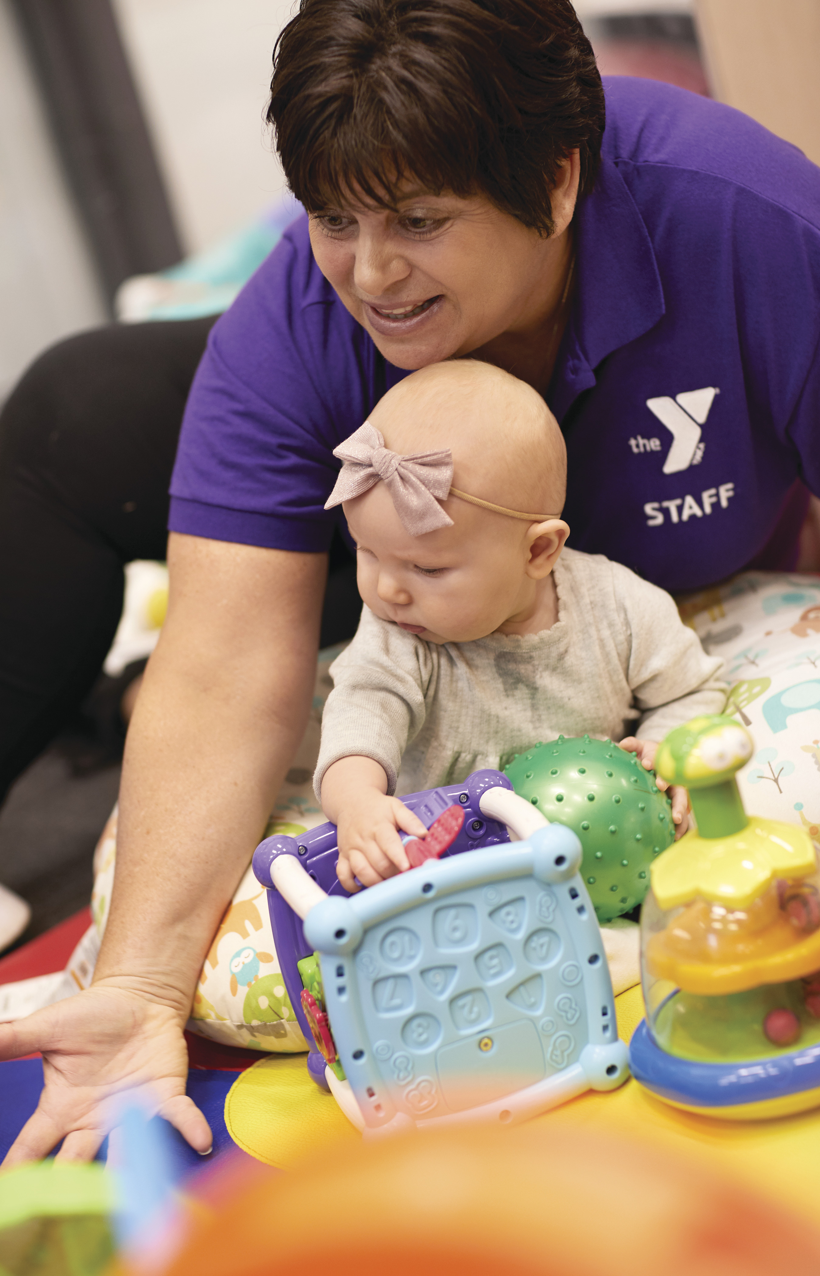 Woman holding babydoll during playtime at YMCA Woman holding babydoll during playtime at YMCA