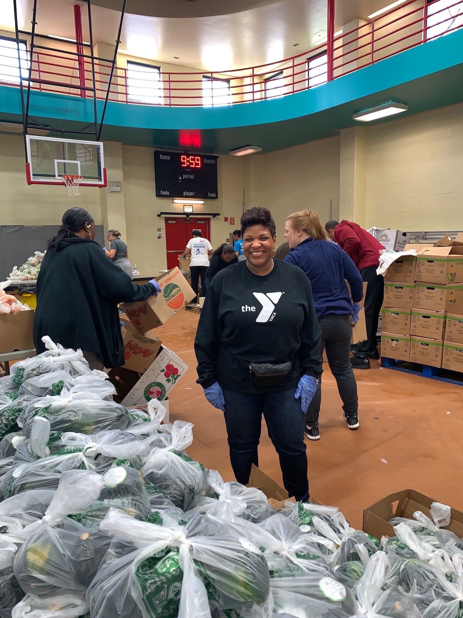 Volunteer in a gym with bags full of donations Volunteer in a gym with bags full of donations