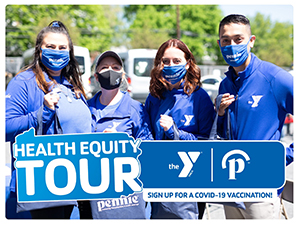 Y staff and volunteers in blue shirts and masks behind a Health Equity Tour sign.