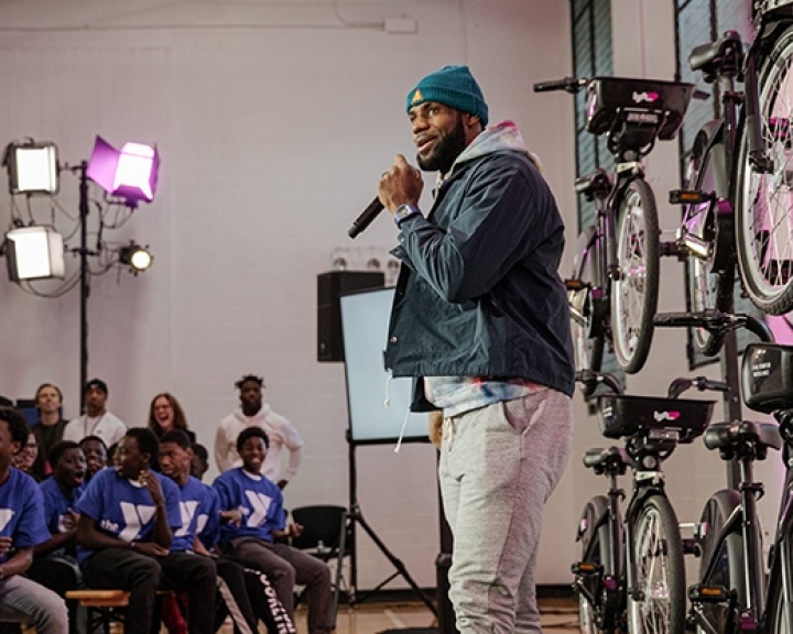 LeBron James speaking on stage in front of bicycles LeBron James speaking on stage in front of bicycles